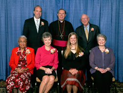 Spirit of Service Award winners, seated from left, are Maxine Ferguson, Lynne O&rsquo;Day, Jenna Knapp and Patty Schmalz. Standing, from left, are Pat Sullivan, Archbishop Daniel M. Buechlein and Robert Sullivan. (Photo by Richard Clark) 