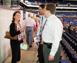 Julie Carr, a member of St. Malachy Parish in Brownsburg, gets assistance from volunteers Christopher Breen and Michael Hussey before the start of the 175th&nbsp;anniversary Mass at Lucas Oil Stadium in Indianapolis on May 3. Breen and Hussey are also members of St. Malachy Parish in Brownsburg. (Photo by Mike Krokos) 