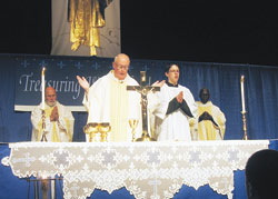 Msgr. Joseph F. Schaedel celebrates Mass during the &ldquo;Treasuring Womanhood&rdquo; conference on April 18 at the Indianapolis Convention Center. Also pictured, from left, are Msgr. Harold Knueven, administrator of St. Mary Parish in Greensburg; altar server Timothy DeCrane, a member of Our Lady of the Most&nbsp;Holy Rosary Parish in Indianapolis; and Father Luca Amandua, a priest visiting from the Diocese of Arua, Uganda. (Photo by Ann Margaret Lewis) 
