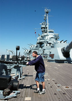 St. Michael the Archangel parishioner Dan Roth of Plymouth, Ind., in the Fort Wayne-South Bend Diocese, examines a large gun on the deck of the USS Alabama, which is moored along the shore at Mobile, Ala., and serves as a naval museum. His grandfather, Seaman First&nbsp;Class Paul L. Travis, served in the U.S.&nbsp;Navy on board the battleship for three&nbsp;years during World War II. (Photo by Mary Ann Wyand) 