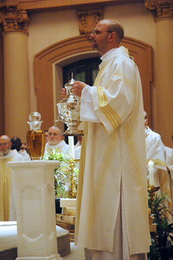 Deacon Jeremy Gries holds an urn containing chrism to be blessed by Archbishop Daniel M. Buechlein during the April 7 archdiocesan chrism&nbsp;Mass celebrated at SS.&nbsp;Peter and Paul Cathedral in Indianapolis. Archbishop Buechlein will anoint the hands of Deacon&nbsp;Gries and deacons John Hollowell and Peter Marshall when he ordains them to the priesthood on June&nbsp;6 at SS. Peter and Paul Cathedral. (File photo by Sean Gallagher) 