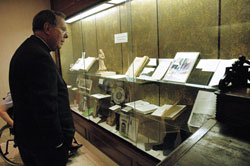 Archbishop Daniel M. Buechlein looks at artifacts that are displayed behind glass at the Old Cathedral Library in Vincennes, Ind., on March 18. In celebration of the 175th anniversary of the Archdiocese of Indianapolis, Archbishop Buechlein will lead a second pilgrimage for adults to historic Vincennes on Sept. 12. (File photo by Mary Ann Wyand)