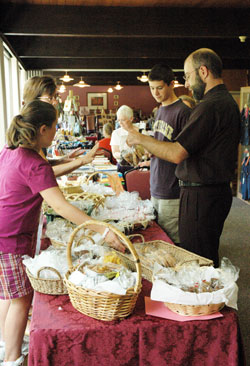 Father Todd Goodson, pastor of St. Monica Parish in Indianapolis, buys baked goods on Aug. 1 during the fourth annual &ldquo;Missions Helping Missions Bazaar&rdquo; at Our Lady of Fatima Retreat House in Indianapolis. (Photo by Mary Ann Wyand)