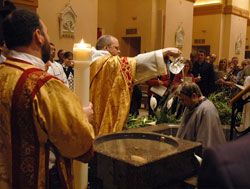 Benedictine Father Julian Peters, at the time the administrator pro-tem of SS. Peter and Paul Cathedral Parish in Indianapolis, baptizes Scott Warpool during Cathedral Parish&rsquo;s Easter Vigil on March 22, 2008. The Easter Vigil is the culmination of the journey of faith taken by people seeking to enter into the full communion of the Church through the Rite of Christian Initiation of Adults (RCIA). Proposed archdiocesan RCIA guidelines are currently being tested in several parishes across central and southern Indiana. (File photo by Sean Gallagher) 