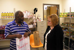 As the new director of the Crisis Office, Stephanie Davis, right, leads a team of staff members and volunteers who work to bring hope and help to people in need. Here, she talks to volunteer Jerry&nbsp;Thomas in the food pantry of the Crisis Office, an emergency assistance program of Catholic&nbsp;Charities Indianapolis. (Photo by John Shaughnessy) 