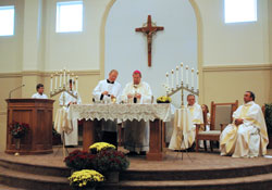 Archbishop Daniel M. Buechlein, assisted by Father Patrick Beidelman, the master of ceremonies, prays the first eucharistic prayer during the Mass of Blessing a Church and Altar on Sept. 26 at the new St. Ann Church in Indianapolis. Father Harold Rightor II, seated at right near the altar, served as associate pastor of St. Ann Parish from 2007-09 and now serves as pastor of Annunciation Parish in Brazil. Father Glenn O&rsquo;Connor, pastor of St. Ann and St. Joseph parishes in Indianapolis, is seated at the far right side of the altar. (Photo by Mary Ann Wyand) 