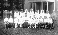 Members of the first and solemn Communion classes of 1932 at Immaculate Conception Parish in Millhousen pose with their pastor, Father Carl Riebenthaler. Ruth Beesley, sixth from left in the back row, 92, recently recalled how the priest, who served as the parish&rsquo;s pastor for 43 years, was greatly loved by the members of the parish. (Submitted photo)
