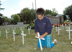St. Michael School eighth-grader Briana Stewart of Indianapolis helped hammer crosses into the ground on Sept. 19 with her parents, Grant and Naomi Stewart, and her older twin sisters, Madeline and Melinda. They are members of St. Michael the Archangel Parish. More than 100 parishioners and students from St.&nbsp;Michael School, Cardinal Ritter Jr./Sr. High School, Bishop Chatard High School and Marian University, all in Indianapolis, helped erect the pro-life display. (Photo by Mary Ann Wyand) 