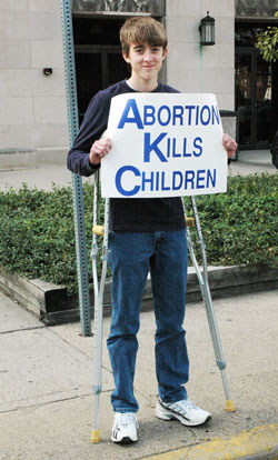 Bobby Vogel, a member of St.&nbsp;Joseph Parish in Jennings County, leans on crutches while he prays during the Central Indiana Life Chain on Oct. 4 along North Meridian Street in Indianapolis. (Photo by Mary Ann Wyand) 