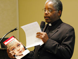 Father Kenneth Taylor, pastor of Holy Angels Parish in Indianapolis and director of the archdiocesan Office of Multicultural Ministry, discusses a story in Newsweek magazine, which addressed the question, &ldquo;Is your baby racist?&rdquo; He said people need to understand the reality of certain aspects of other cultures. (Photo by Mary Ann Wyand) 