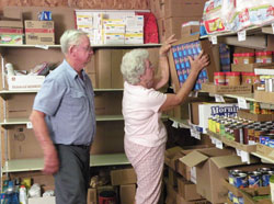Leroy and Marlene Oser, members of St. Martin of Tours Parish in Siberia, work on Aug. 19 at Martin&rsquo;s Cloak, a food and clothing bank located at their parish that is a program of Catholic Charities Tell City. (Submitted photo)
