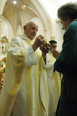 Retired Father Frank Eckstein gives Communion to&nbsp;a worshipper at a Feb. 26, 2007, Mass at St.&nbsp;Louis Church in Batesville. In retirement, Father Eckstein has been the sacramental minister for eight years at St.&nbsp;Charles Borromeo Parish in Milan and St. Pius Parish in Ripley County. (File photo by Sean Gallagher)