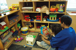 Two brothers who will temporarily reside at the new Holy Family Shelter in Indianapolis with their parents and siblings enjoy play time together in the children&rsquo;s day care center during a Dec. 6 open house. (Photo by Mary Ann Wyand)