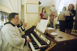 Seminarian Jerry Byrd directs the choir of St. John the Baptist Parish in Osgood during a Nov. 22 Mass at the parish&rsquo;s church. (Photo by Sean Gallagher)