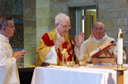 Msgr. Richard Kavanagh, center, prays a eucharistic prayer during a June 2, 2006, Mass at St. Paul Hermitage in Beech&nbsp;Grove on the occasion of the 70th anniversary of his priestly ordination. Concelebrating with him were, from left, Father Henry Brown and Father John Sciarra, both retired priests in residence at the Hermitage. Msgr. Kavanagh died on Jan. 20. Father Brown died in 2009, and Father Sciarra died in 2007. (File photo by Sean Gallagher)