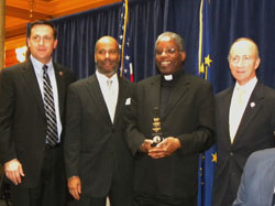 Indiana Gov. Mitch Daniels, right, presented a 2010 Freedom Award to Father Kenneth Taylor, third from right, during a Jan. 14 ceremony at the Indiana Statehouse. State Rep. Matthew Bell, R-Avilla, left, and Clayton Graham, second from left, also participated in the award presentation. Father Taylor is the pastor of Holy Angels Parish in Indianapolis and director of the archdiocesan Office of Multicultural Ministry. (Submitted photo/courtesy Governor&rsquo;s Office)