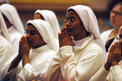 Sister Saima Mary, left, and Sister Rosalind Mary, both members of the Franciscan Sisters of the Immaculate Heart of Mary, kneel in prayer during the Jan. 31 World Day for Consecrated Life Mass at SS. Peter and Paul Cathedral in Indianapolis. Both sisters minister at St. Francis Hospital in Beech Grove. (Photo by Sean Gallagher)