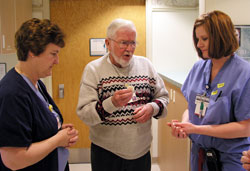 As an extraordinary minister of holy Communion, Gene Caviston brings Communion to hospital patients and staff members at St. Francis Hospital in Indianapolis. Here, Caviston offers a prayer before giving Communion to two nurses in the hospital&rsquo;s labor and delivery unit, Amelia Titsworth, left, and Lisa Bauer. (Photo by John Shaughnessy)
