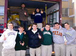 The Cathedral High School family was more than happy recently to gather donations for refugee families being resettled in the archdiocese through Catholic Charities Indianapolis. Shown packing a Catholic Charities&rsquo; truck with donated goods, are, front row, from left, John White, Jack Christ, Ryan Thie, Levi Kinney, Jacob Robinson and Michael Cohoat. Standing in the truck are, left, Tim Winn, donations volunteer coordinator for Catholic Charities&rsquo; Refugee Resettlement program, and Michael Venezia. (Submitted photo)