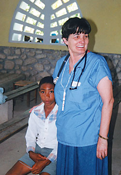 Registered nurse Sue Alexander prepares to help a Haitian boy during one of her medical mission trips to St. Jean Marie Parish in Belle&nbsp;Riviere with St. Thomas Aquinas Parish Haiti Committee volunteers. Alexander miraculously survived the Jan. 12 earthquake in Port-au-Prince. (Submitted photo)
