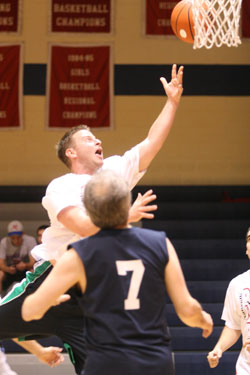 Competitors reached for the goal of raising funds for an alcohol and drug awareness program during an April 16 basketball game that matched staff members from Roncalli&nbsp;High School in Indianapolis against doctors from St.&nbsp;Francis Hospital & Health Centers. Brian Lauck, an assistant coach for the Roncalli football team, swoops toward the basket in the Docs vs. Jocks vs. Drugs game. (Submitted photo)