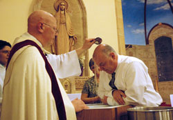 Father John McCaslin baptizes Wallace &ldquo;Wally&rdquo; Miller of Indianapolis during the Easter&nbsp;Vigil Mass on Holy Saturday, April 3, at St.&nbsp;Anthony Church in Indianapolis. Miller&rsquo;s wife, Debbie, was his Rite of Christian Initiation of Adults sponsor. Father McCaslin is the pastor of St. Anthony Parish and administrator of Holy&nbsp;Trinity Parish in Indianapolis. (Photo by Mary Ann Wyand)