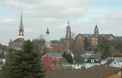 Spires dot Oldenburg&rsquo;s skyline, a historic village nestled in the hills of southeastern Indiana that was founded by German immigrants in 1837. The onion dome spire, second from left, was recently installed. It was modeled after a similar structure that sat atop Holy Family Parish&rsquo;s old stone church from 1846 until 1949. (Photo by Sean Gallagher)