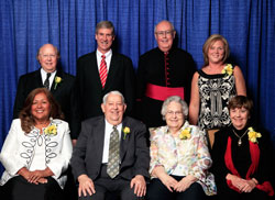 Spirit of Service winners, seated from left, are Maria Pimentel-Gannon, George Jennings, Maryfrances &ldquo;Mike&rdquo; Jennings and Margie Pike. Standing, from left, are Tom Hirschauer Jr., Indiana University head football coach Bill Lynch, Msgr. Joseph F. Schaedel and Julie Molloy. (Photo by Richard Clark)