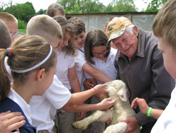 Students from St. Roch School in Indianapolis surround 92-year-old Art Huser and one of the sheep that he raises and shepherds at his 10-acre home on the south side of the city. St. Roch teacher Dick Gallamore refers to Huser as &ldquo;a modern-day St. Francis of Assisi.&rdquo; (Submitted photo)
