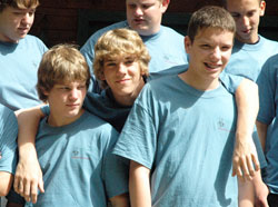 Troy Kunkel, center, puts his arms around James Hood, left, and Liam Mitchel on June 17 during Bishop Brut&eacute; Days at the Future Farmers of America Leadership Center in southern Johnson County. Troy is a member of St. Mary Parish in Greensburg. James is a member of St. Malachy Parish in Brownsburg. Liam is a member of St. Joseph Parish in Shelbyville. (Photo by Sean Gallagher)