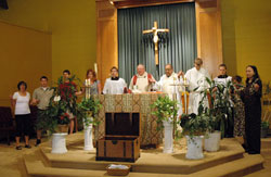 During Mass on the feast of the Body and Blood of Christ on June 6, Father Larry Crawford, the pastor of St. Gabriel the Archangel Parish in Indianapolis since 1999, prays the Lord&rsquo;s Prayer with Deacon Oscar Morales, the pastoral associate, and parishioners. The liturgy marked the final celebration of the Eucharist before the start of the $508,000 church renovation project, which will transform the interior during the next six months. (Photo by Mary Ann Wyand)