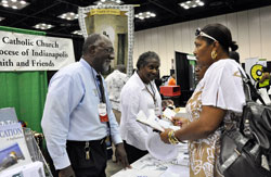 Holy Cross Brother Roy Smith, left, and his sister, Sister Demetria Smith, a member of the Missionary Sisters of Our Lady of Africa, talk with Karlynn Jordan, right, of Indianapolis at the Church&rsquo;s &ldquo;Faith and Family&rdquo; booth on July 17 during the Indiana Black Expo&rsquo;s 40th&nbsp;annual &ldquo;Summer Celebration&rdquo; at the Indiana&nbsp;Convention Center in Indianapolis. (Photo by Mary Ann Wyand)