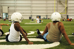 Football players from the Mother Theodore Catholic Academies do stretches during a practice on Aug. 18 at the indoor facility where the Indianapolis Colts prepare for their games. The Mother Theodore Catholic Academies will field combined football teams for the first time this year, thanks to funds from a Super Bowl raffle made possible by Indianapolis Colts&rsquo; president Bill Polian. (Photo by John Shaughnessy)