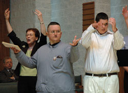 St. Mark the Evangelist parishioner Chuck Ward of Indianapolis, center, sings and uses hand gestures during the archdiocesan SPRED&nbsp;Mass for Special Religious Development participants on April 27, 2008, at St. Mark the Evangelist Church. Joining him as music ministers for the liturgy are, left, St. Mark parishioner and volunteer catechist Jean Milharcic and, right, SPRED participant Nick Shewman from Nativity of Our Lord Jesus Christ Parish in Indianapolis. For more information about the SPRED program, call Ken Ogorek at 317-236-1446 or 800-382-9836, ext. 1446. (File photo by Mary Ann Wyand)