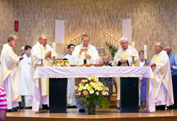 Archbishop Daniel M. Buechlein, center, prays at the altar during a Sept. 19 Mass at St. Michael Church in Greenfield. The Mass celebrated the 150th anniversary of the founding of the parish. Joining Archbishop Buechlein at the altar are, from left, Father Stanley Herber, Deacon Wayne Davis, Benedictine Father Severin Messick, St. Michael&rsquo;s current pastor, and Father Joseph Riedman. Father&nbsp;Herber and Father Riedman are previous pastors. Standing behind the clergy are altar servers and extraordinary ministers of holy&nbsp;Communion. (Submitted photo)
