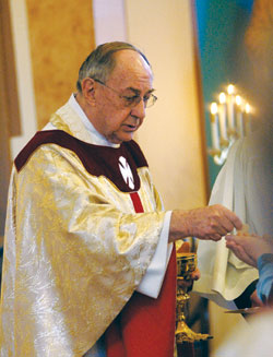 Retired Father Joseph Sheets distributes Communion during a March 19, 2009, Mass at St. Joseph Church in Jennings County. Retired since 2001, Father Sheets has provided sacramental assistance during weekend Masses at many parishes across the archdiocese for nearly a decade. The &ldquo;Christ Our Hope: Compassion in Community&rdquo; annual appeal provides support for the archdiocese&rsquo;s retired priests. (File photo by Mary Ann Wyand)