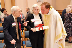 Father George Plaster, the pastor of St. Mark the Evangelist Parish in Indianapolis, congratulates two of his longtime parishioners, Donald and Ruth Allen, on their 70 years of married life following the archdiocesan Golden&nbsp;Wedding Anniversary Mass on Oct. 17 at SS. Peter and Paul Cathedral in Indianapolis. (Photo by Mary Ann Wyand)