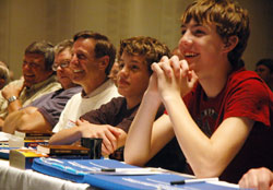 Jim Dickey, third from left, and his two sons, Connor and Jordan, laugh during a talk given by Father Larry Richards during the fifth annual Indiana Catholic Men&rsquo;s Conference on Oct. 16 at the Indiana Convention Center in Indianapolis. Dickey, an organizer of the conference, and his family are members of St. Louis Parish in Batesville. (Photo by Sean Gallagher)