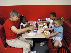 Doris Jackson, an assistant for the preschool operated at Ryves Hall in Terre Haute, helps some of the children at the preschool enjoy a pancake breakfast in June 2004 at the Terre&nbsp;Haute Catholic Charities Food Bank. Catholics in west central Indiana support the programs of Catholic Charities Terre Haute through their contributions to &ldquo;Christ Our Hope: Compassion in Community.&rdquo; (File photo by Brandon A. Evans)