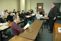 Father Robert Robeson, right, rector of Bishop Simon Brut&eacute; College Seminary in Indianapolis, teaches a class on Catholic beliefs and practices on Dec. 1 at Marian University in Indianapolis. Most of the students in the class are seminarians. Marian provides the intellectual formation for Bishop Brut&eacute;&rsquo;s seminarians. Human, spiritual and pastoral formation for the seminarians takes place at the seminary. (Photo by Sean Gallagher)