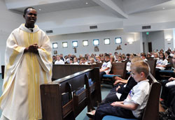 Father Rodolphe Balthazar, the pastor of St. Nicholas Parish in Mole, Haiti, tells Our Lady of the Greenwood students and parishioners about life in the impoverished island nation during his homily on Oct. 22 at Our Lady of the Greenwood Church in Greenwood. He said Haitians walk several miles looking for food and water each day. &ldquo;When you put your hands together for Haiti, you give hope,&rdquo; Father Rodolphe said. &ldquo;You pray for us. You work for us. Thank you for that.&rdquo;	(Photo by Mary Ann Wyand)