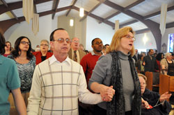 St. Gabriel the Archangel parishioners Stephen Tsareff and Sharon Porter of Indianapolis hold hands as they pray the Lord&rsquo;s Prayer during the Mass of Dedication on Feb. 6 at St. Gabriel the Archangel Church in Indianapolis. (Photo by Mary Ann Wyand)