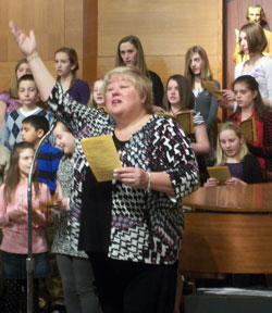 Choir members at Holy Family School in New Albany join Lori&nbsp;True in a performance of &ldquo;A Place at the Table&rdquo; on Feb. 2 at the parish church. A recording artist, True composed and recorded the musical piece that was chosen as the theme for the 2010-11 academic year at Holy Family School. True was invited to the school during Catholic Schools Week. (Submitted photo)