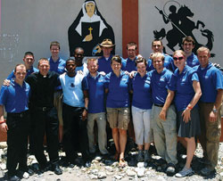 Members of a young adult mission team from the Archdiocese of Indianapolis traveled to Haiti on May 10-17, 2010, with Father Rick Nagel. Posing for a photo in front of images of St. Theodora Gu&eacute;rin and St. George in Bassin-Bleu, Haiti, last spring are, front row, from left, seminarian Tyler Tenbarge, Father Nagel, Father Jean Gregory Jeudy from Haiti, Matt Johnson, Anne Marie Brummer, Missy Brassie, seminarian Tony Hollowell, Erica Heinekamp and Scott&nbsp;Goley, and back row, from left, Scott Lutgring, Steve Rogers, Father Rodolphe Balthazar from Haiti, Michael Conner, Michael Gramke, Robert Barnell and Joe Pederson. (Submitted photo)