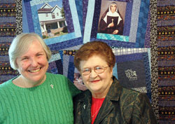 Providence Sisters Barbara McClelland, left, and Rita Ann Wade have been chosen the 2011 Irish Citizens of the Year for their work at Miracle Place, a neighborhood ministry on the near-eastside of Indianapolis. They are shown posing in front of a quilt at Miracle Place. The quilt features a portrait of St. Theodora Gu&eacute;rin, the foundress of their religious order. (Photo by John Shaughnessy)
