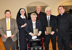 Msgr. Joseph Schaedel, center, and Servants of the Gospel of Life Sister Diane Carollo, second from left, pose for a photograph with archdiocesan Sanctity of Life Award recipients, from left, Our Lady of the Most Holy Rosary parishioner Jerry Mattingly of Indianapolis, St.&nbsp;Mark the Evangelist parishioner Diane Komlanc of Indianapolis, St. Patrick parishioner Tom McBroom of Terre Haute and Father Glenn O&rsquo;Connor, the pastor of St. Ann and St. Joseph parishes in Indianapolis, after the March 3 awards dinner. (Photo by Mary Ann Wyand)