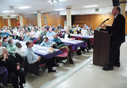 Catholics from central and southern Indiana fill Priori Hall at Our Lady of the Most Holy Rosary Parish in Indianapolis on March 30 to listen to Guy&nbsp;Gruters, right, tell his story of how his faith in God helped him endure nearly six years of confinement as a prisoner of war in North Vietnam. (Photo by Sean Gallagher)