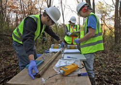 Paul Melillo, left, and Mark Breting, right, inspect soil samples in 2009 from land in Wildwood, Mo., that had been contaminated with dioxin, PCBs and organic chemicals. The employees of Mundell&nbsp;and Associates, an Indianapolis-based environmental services consulting firm, are assisted by Ed Paschal, center, a private environmental consultant for the City of Wildwood. (Submitted photo)