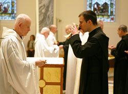 Benedictine Brother Mauritius Honegger, right, drinks from a chalice given to him by Benedictine Father Germain Swisshelm during a May 6 Mass in the Archabbey Church of Our Lady of Einsiedeln in St.&nbsp;Meinrad. Brother Mauritius, a member of Einsiedeln Abbey in Switzerland, is a former member of the Vatican&rsquo;s Swiss Guard, and spent the past academic year as a student at Saint Meinrad Seminary and School of Theology in St. Meinrad. (Photo courtesy of Saint Meinrad Archabbey)
