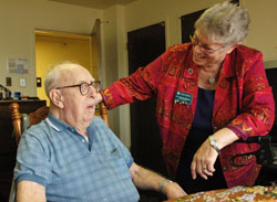 Benedictine Sister Sharon Bierman, longtime administrator of St. Paul Hermitage in Beech Grove, talks with Hermitage resident Harold Dwenger, who is 102. Sister Sharon retired on June 30 after 33 years of ministry at the retirement facility operated by the Sisters of St. Benedict of Our Lady of Grace Monastery. &ldquo;This is their home,&rdquo; she said. &ldquo;The residents feel safe and loved here.&rdquo; (Photo by Mary Ann Wyand)